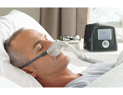 Μηχάνημα CPAP σε χρήση από άντρα σε κρεβάτι
