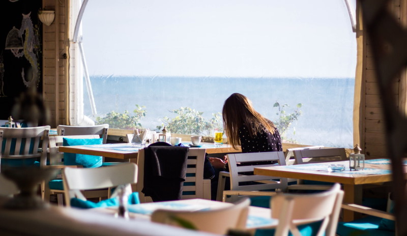 Εστιατόρια με μία κοπέλα δίπλα στην θάλασσα